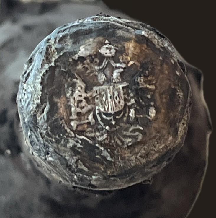 Metal capsule embossed with a crowned coat of arms
