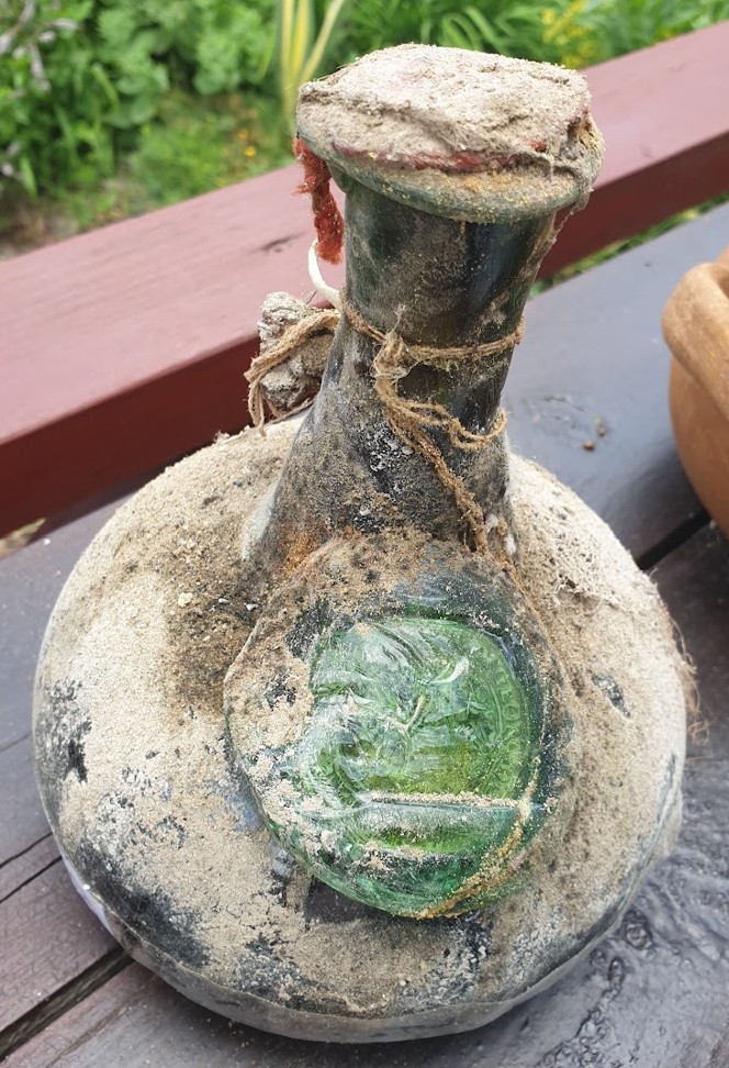 Onion bottle with an applied green glass seal, cord and capsule intact