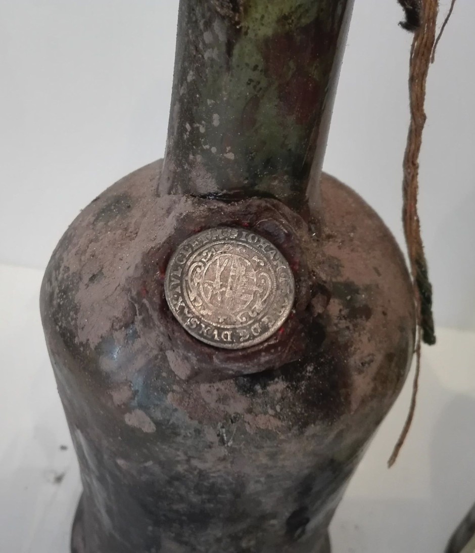 Saxon silver coin set into red wax on the shoulder of a bottle