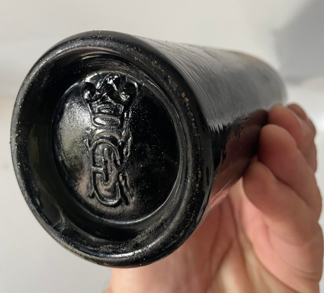 Crowned monogram moulded into the base of a black glass bottle