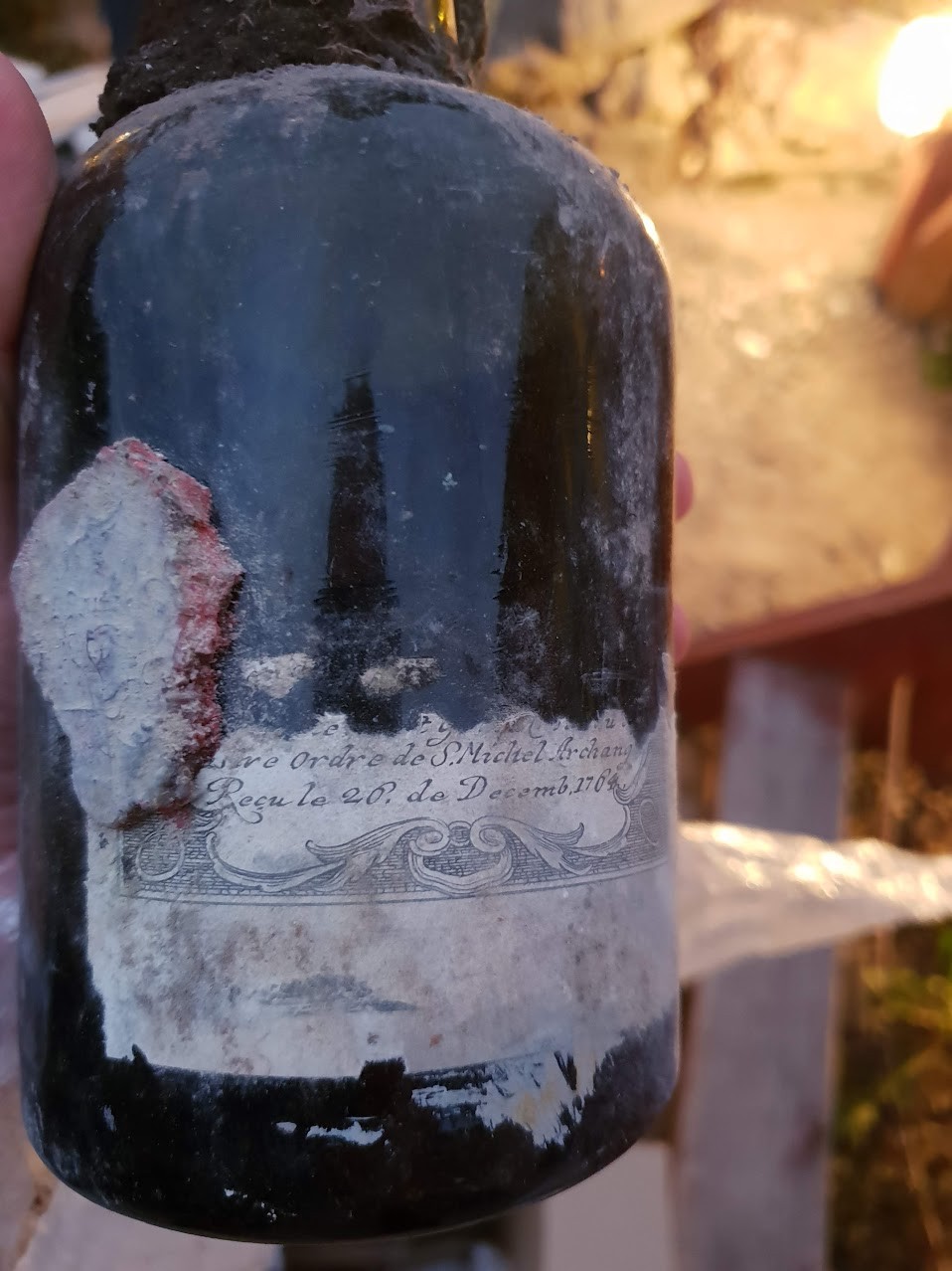 Engraved document pasted to the body of a bottle, mentioning the Ordre de S. Michel Archange and dated 26 December 1764, with a red wax seal alongside