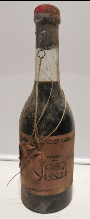 Essence bottle with a printed paper label, wire ring at the neck and a wax-sealed paper over the label