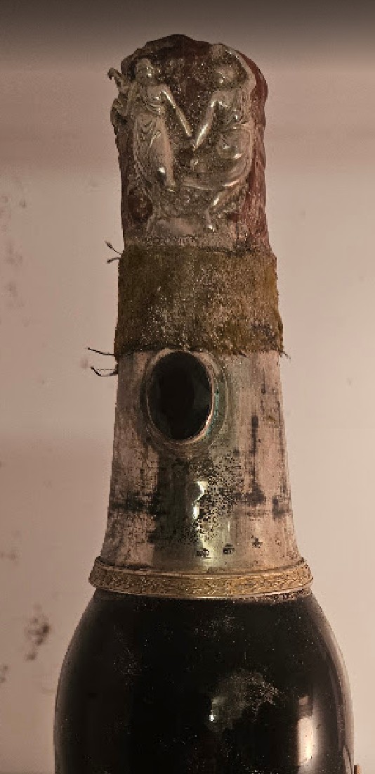 Silver neck mount with figural relief and a set oval stone, wired beneath the wax capsule