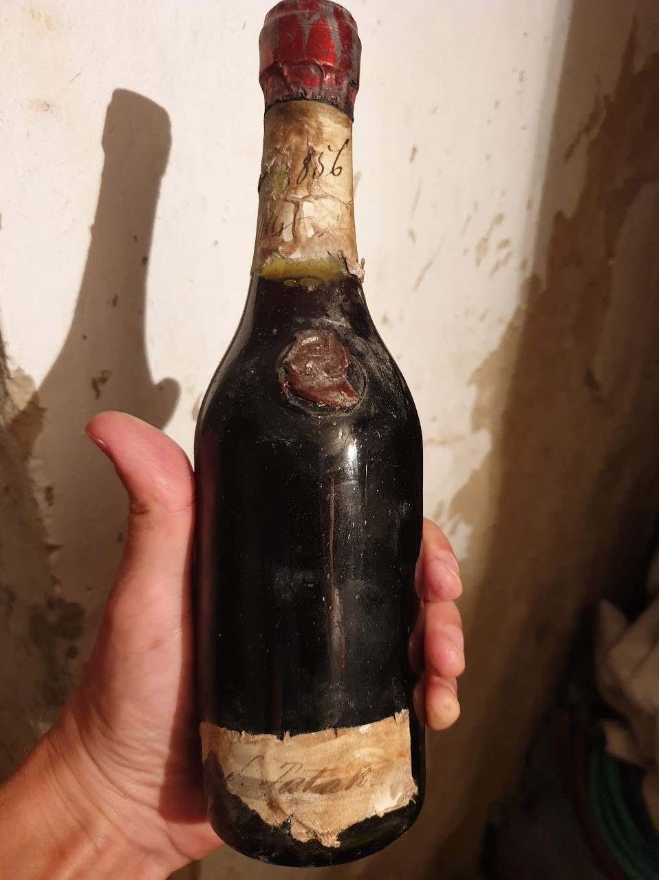 Bottle with a red capsule and dated neck label, a brown wax seal set on the shoulder