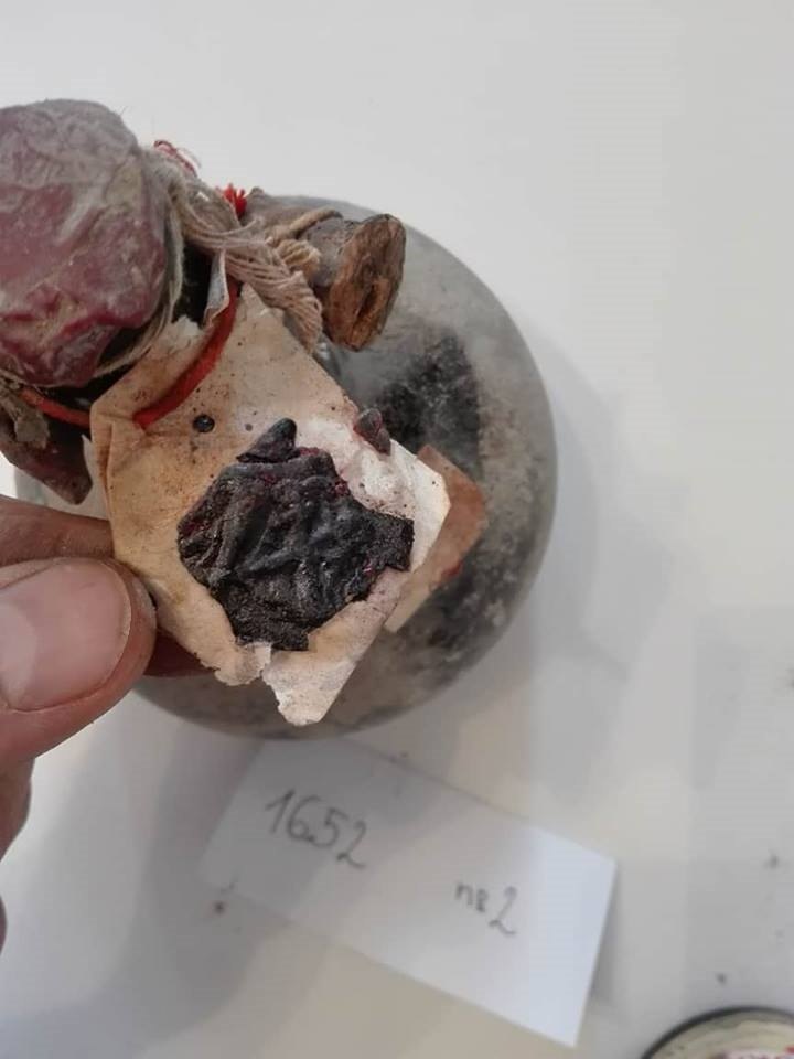 The black wax seal on the paper tag of bottle no. 2