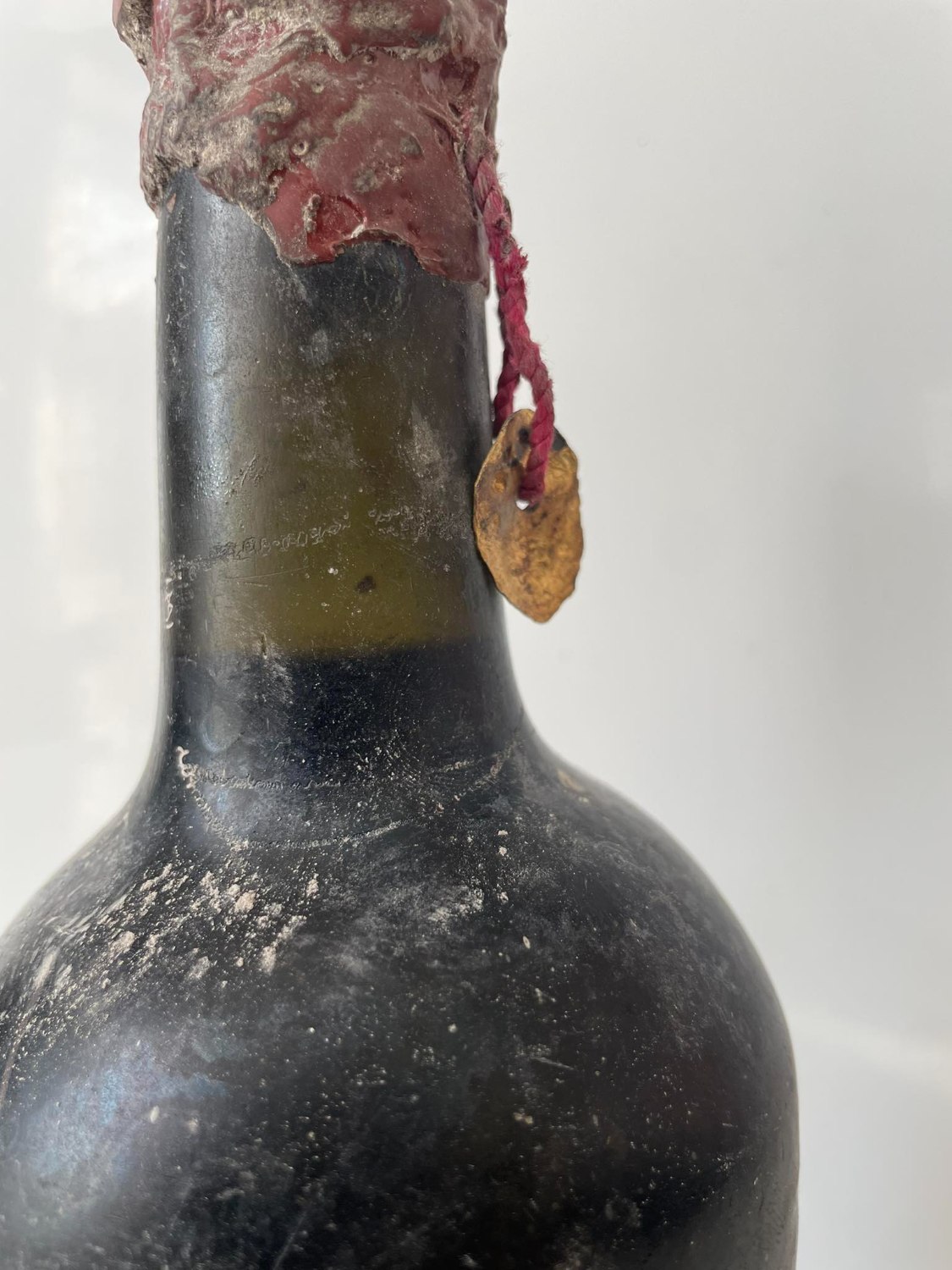 Neck with the wax capsule, the crimson cord and the gilt tag