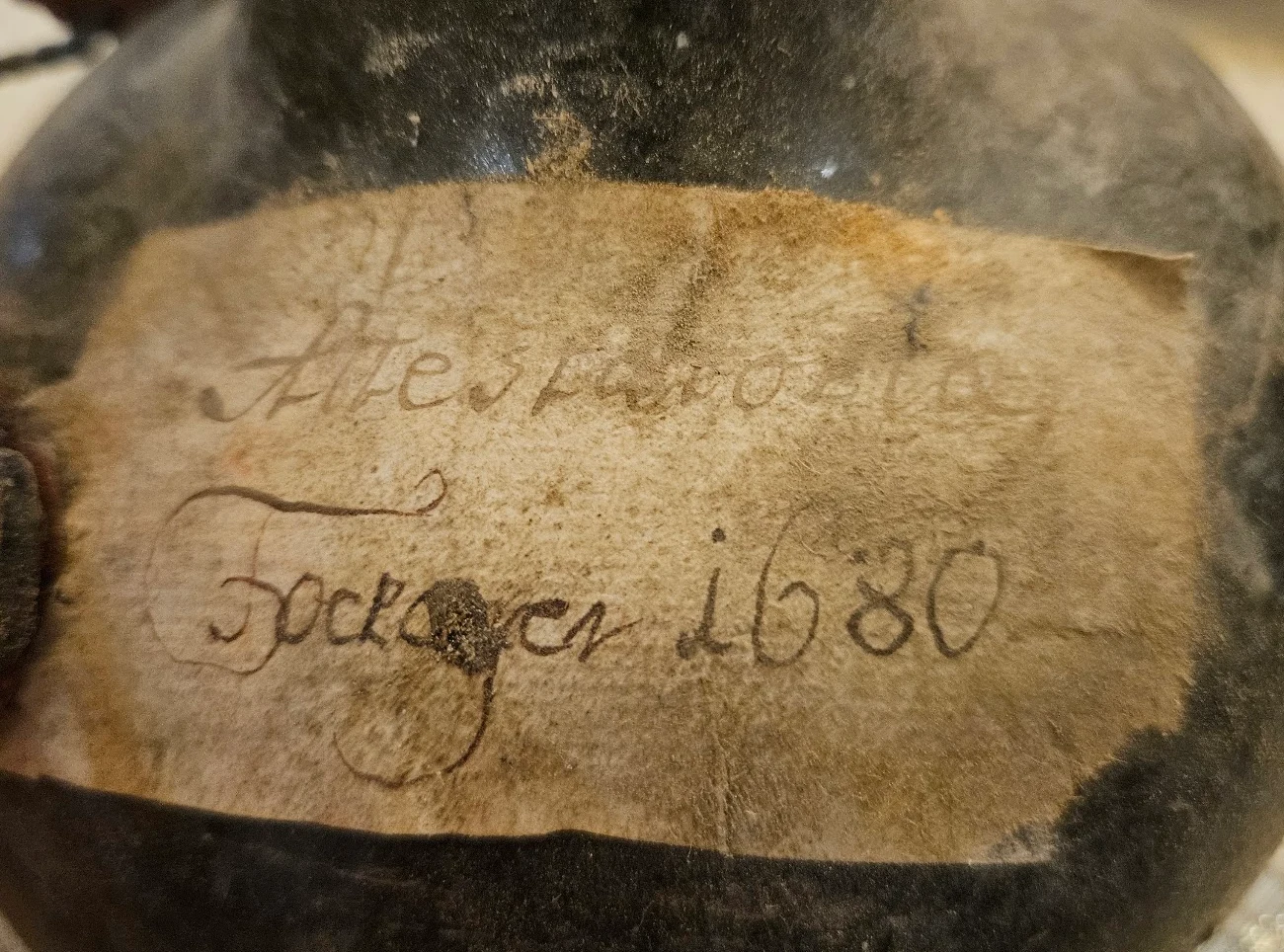 The parchment label in close-up: a first line beginning Altes, and beneath it Tockayer 1680