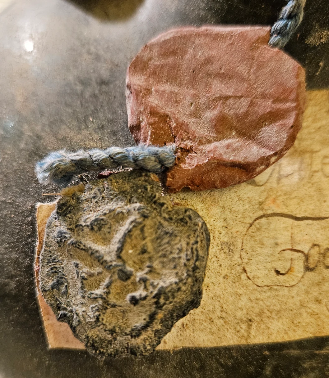 The dark wax seal beside the red one, the impression showing two crossed diagonal bars