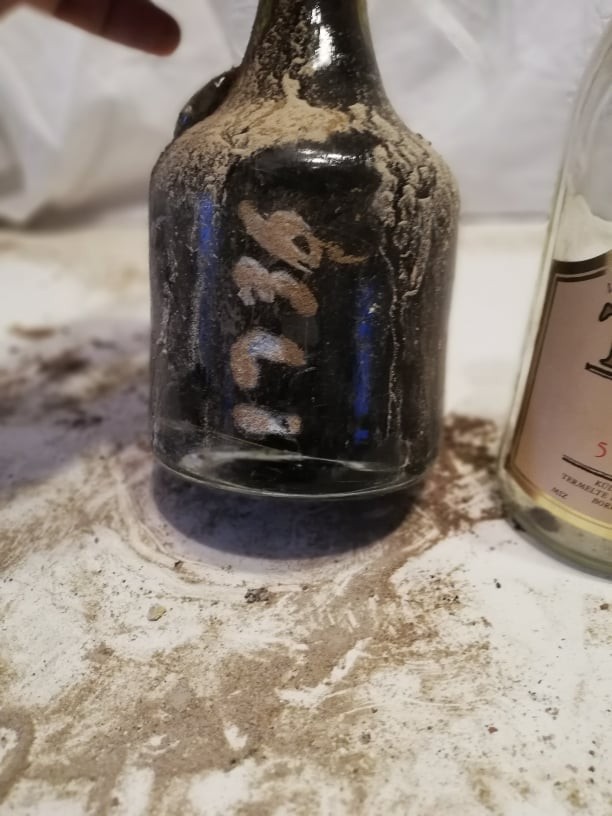 The painted cellar number on the lower body of the bottle