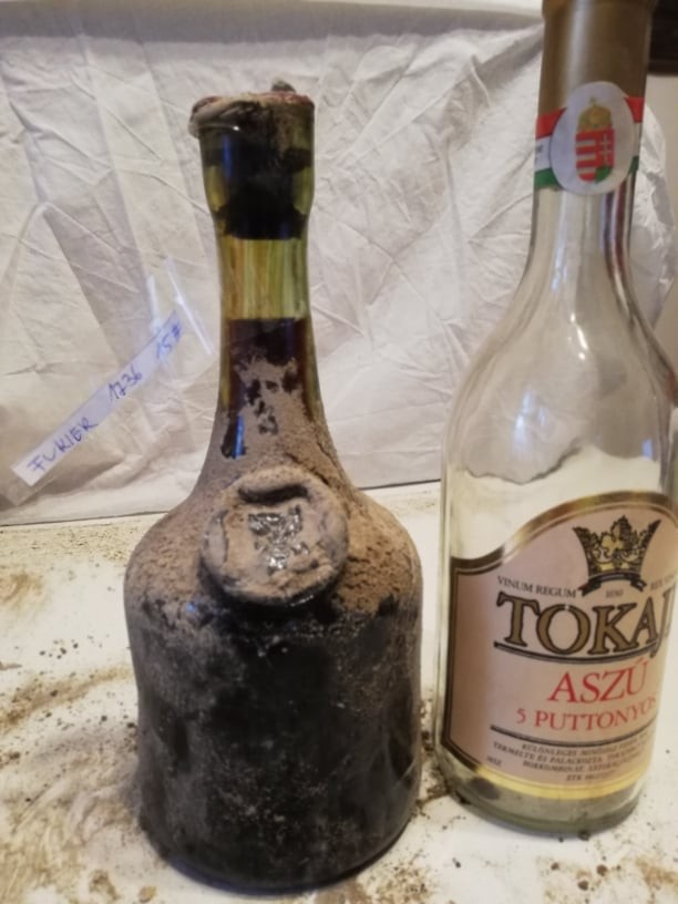 The 1736 bottle beside a modern Tokaji Aszú bottle, glass seal on the shoulder