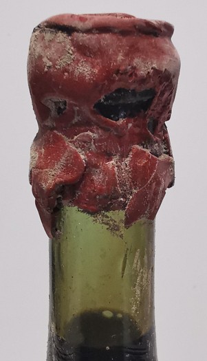 The neck cleaned, showing olive-green glass under the red wax