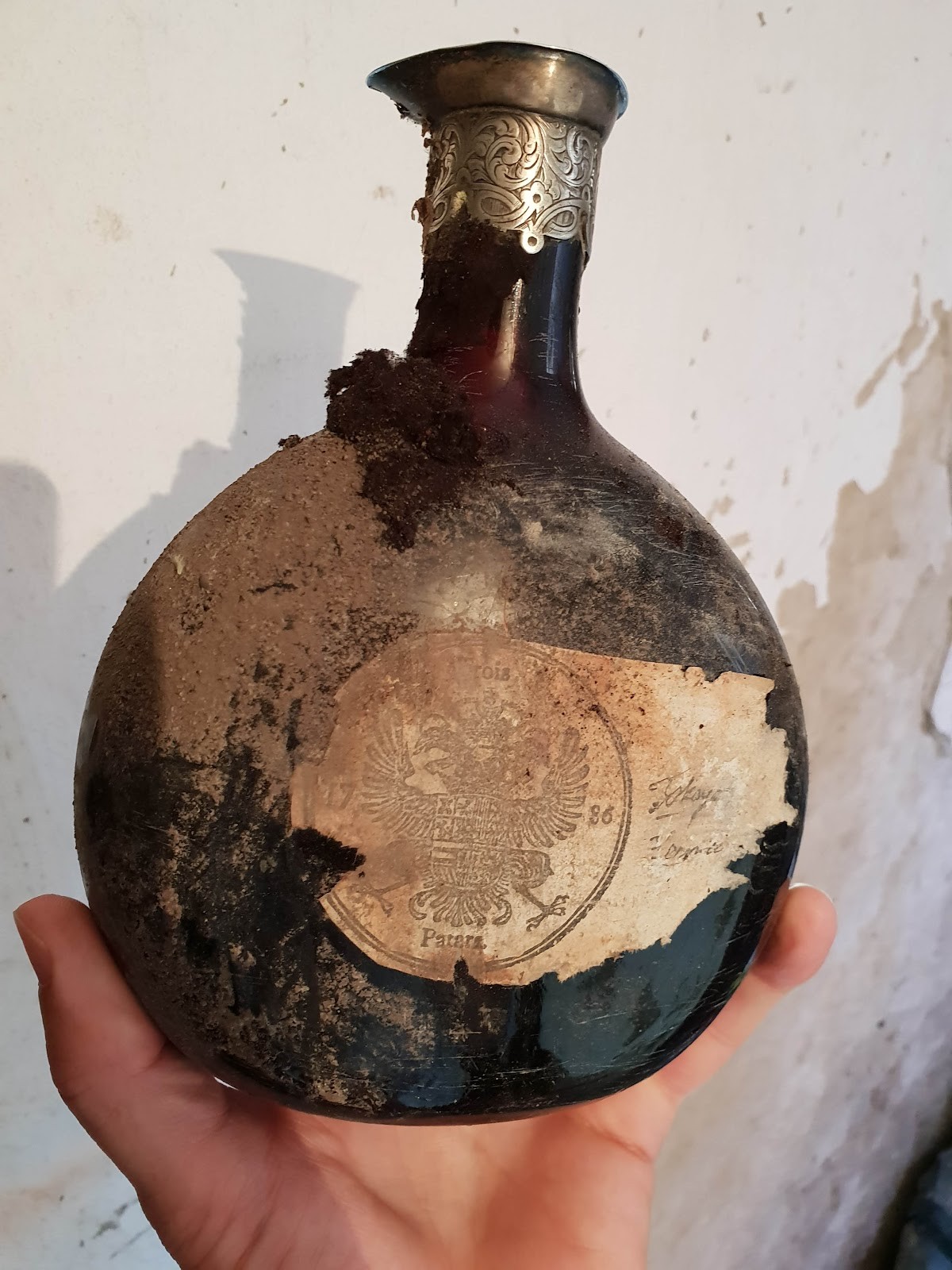 The flattened globular flask, with silver collar and stamped paper label