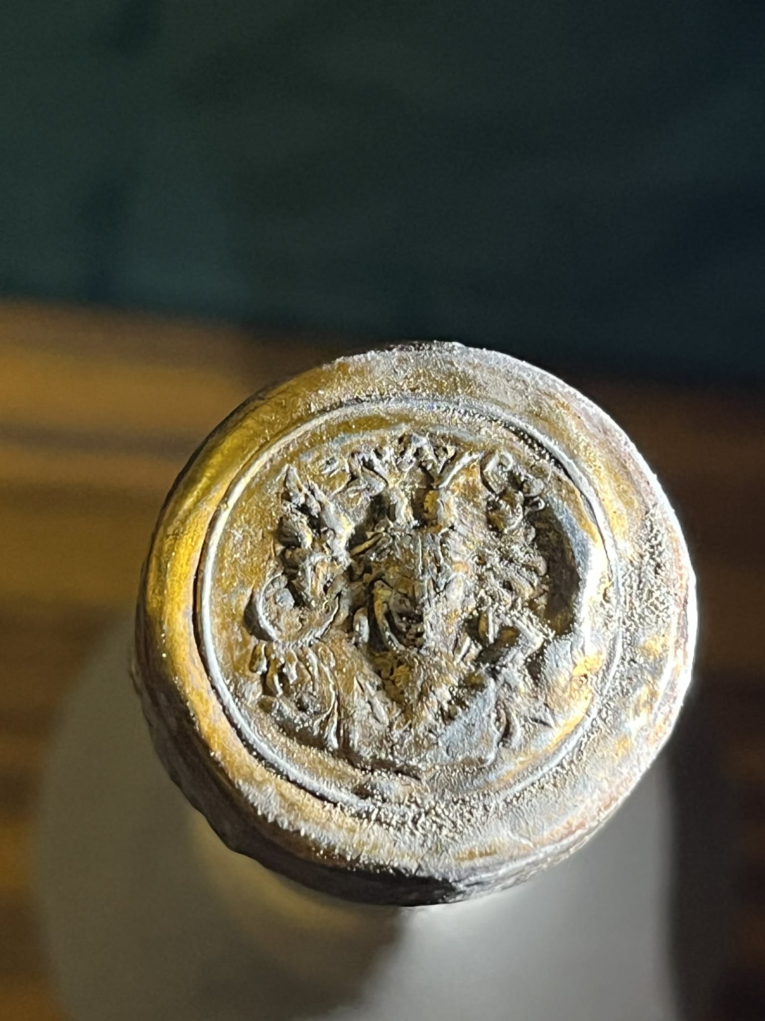 The top of the tin capsule: the Habsburg-Lorraine double eagle with crown and ribbon