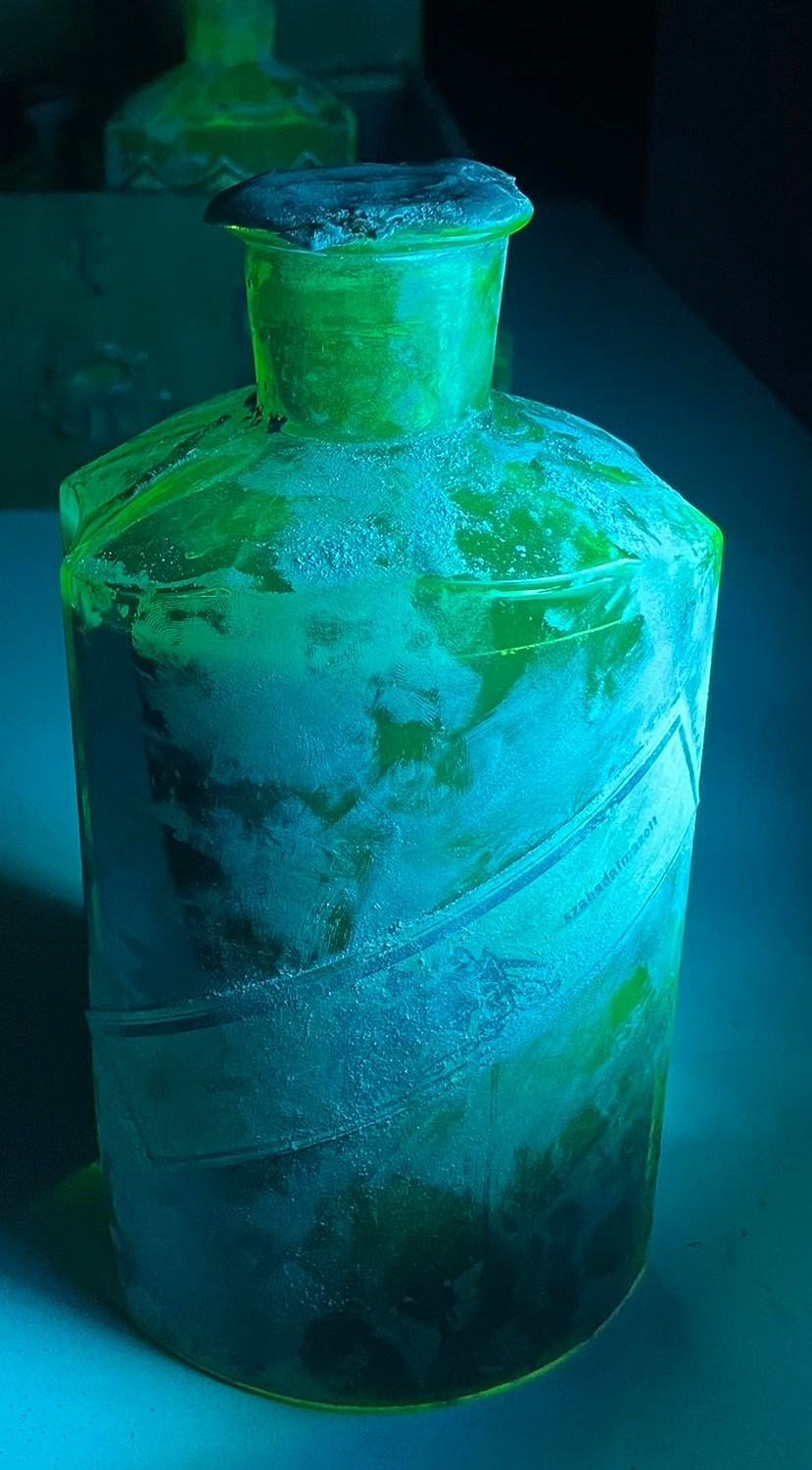 The reverse of the bottle under UV light, the paper band showing szabadalmazott