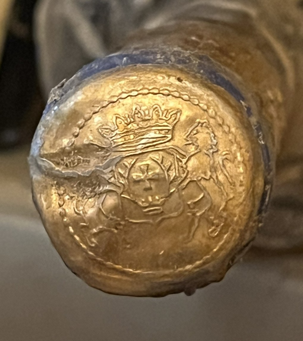 The lead capsule with the Zichy arms in relief: crowned shield, antlers and cross, between two supporters