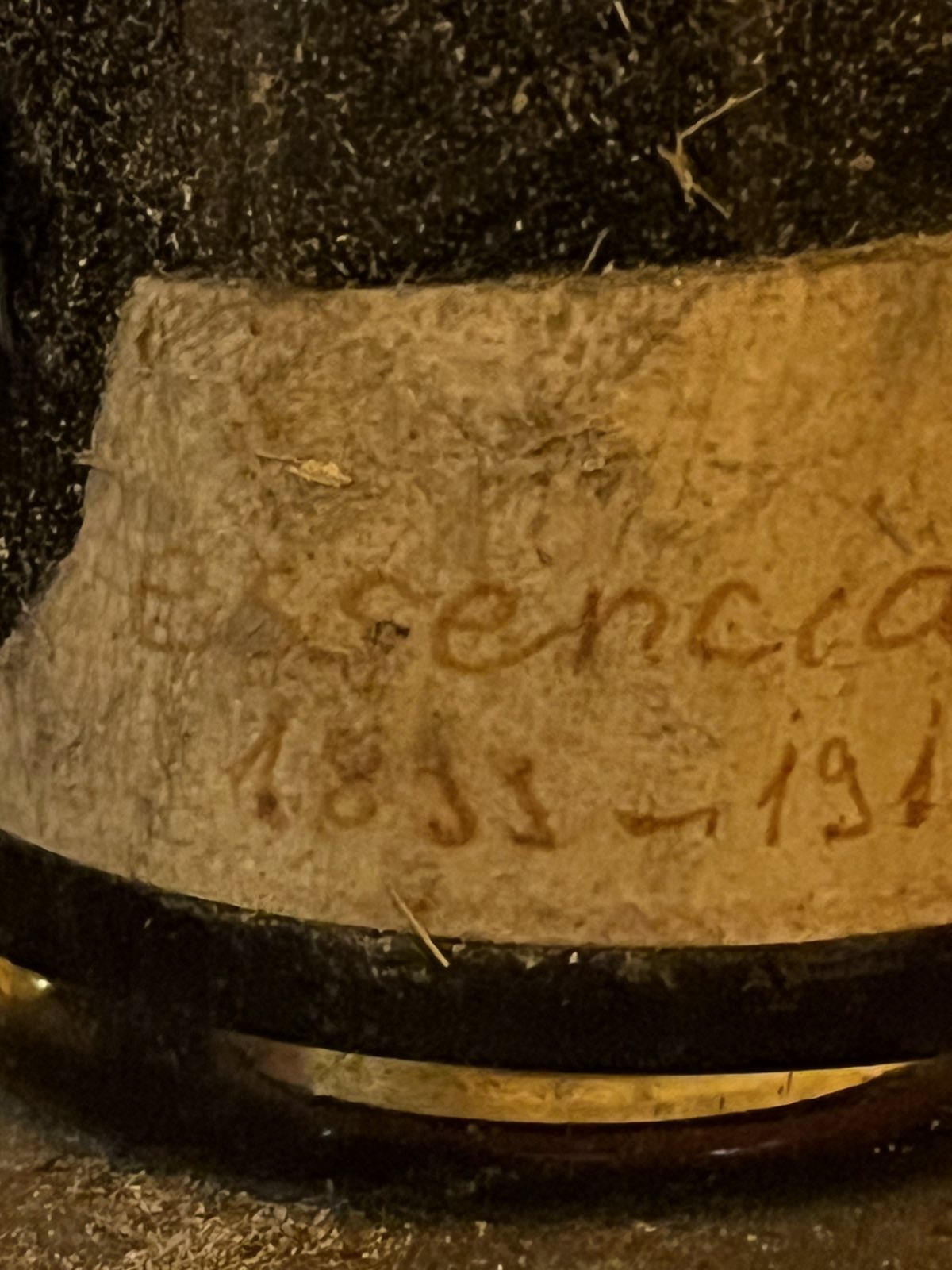 The handwritten band at the base of the bottle reading Essencia and a span of years