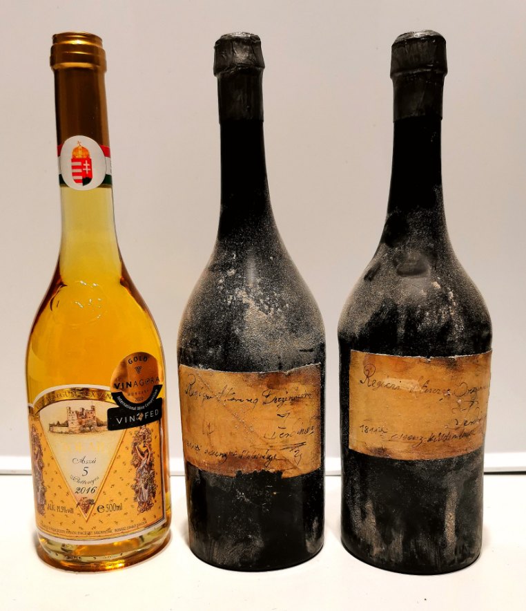 The two black-waxed 1811 essencia bottles of the Bretzenheim consignment, beside a modern 5-puttonyos aszú for scale