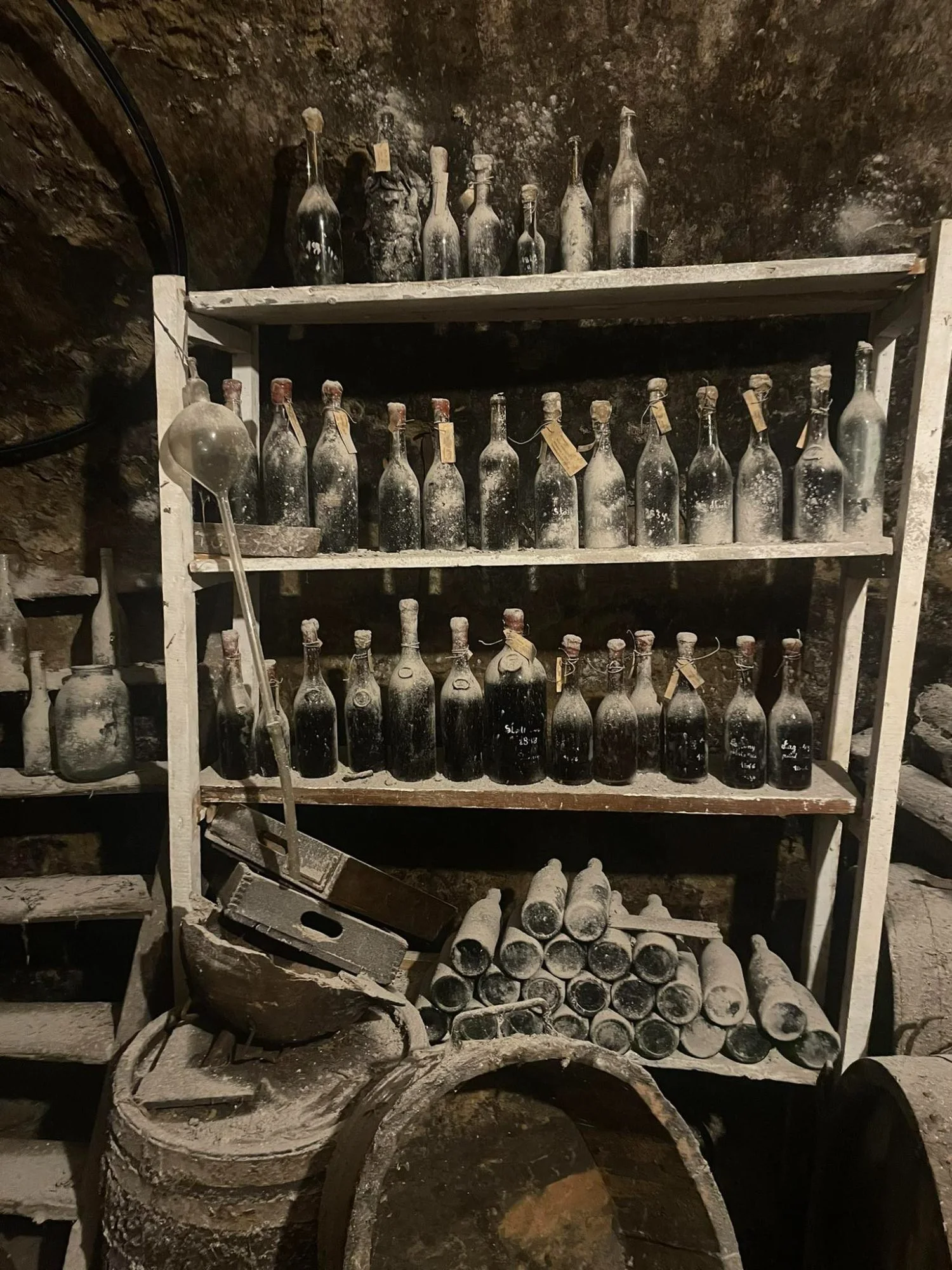 Shelves of old bottles in a vaulted cellar