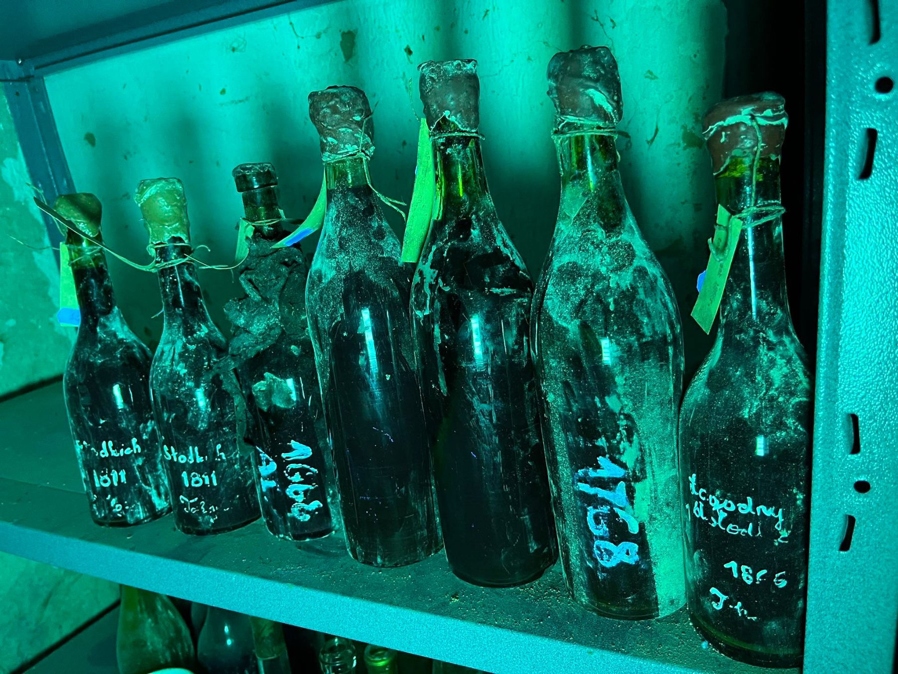 Bottles under ultraviolet light, the vintages chalked on the glass: 1811, 1768