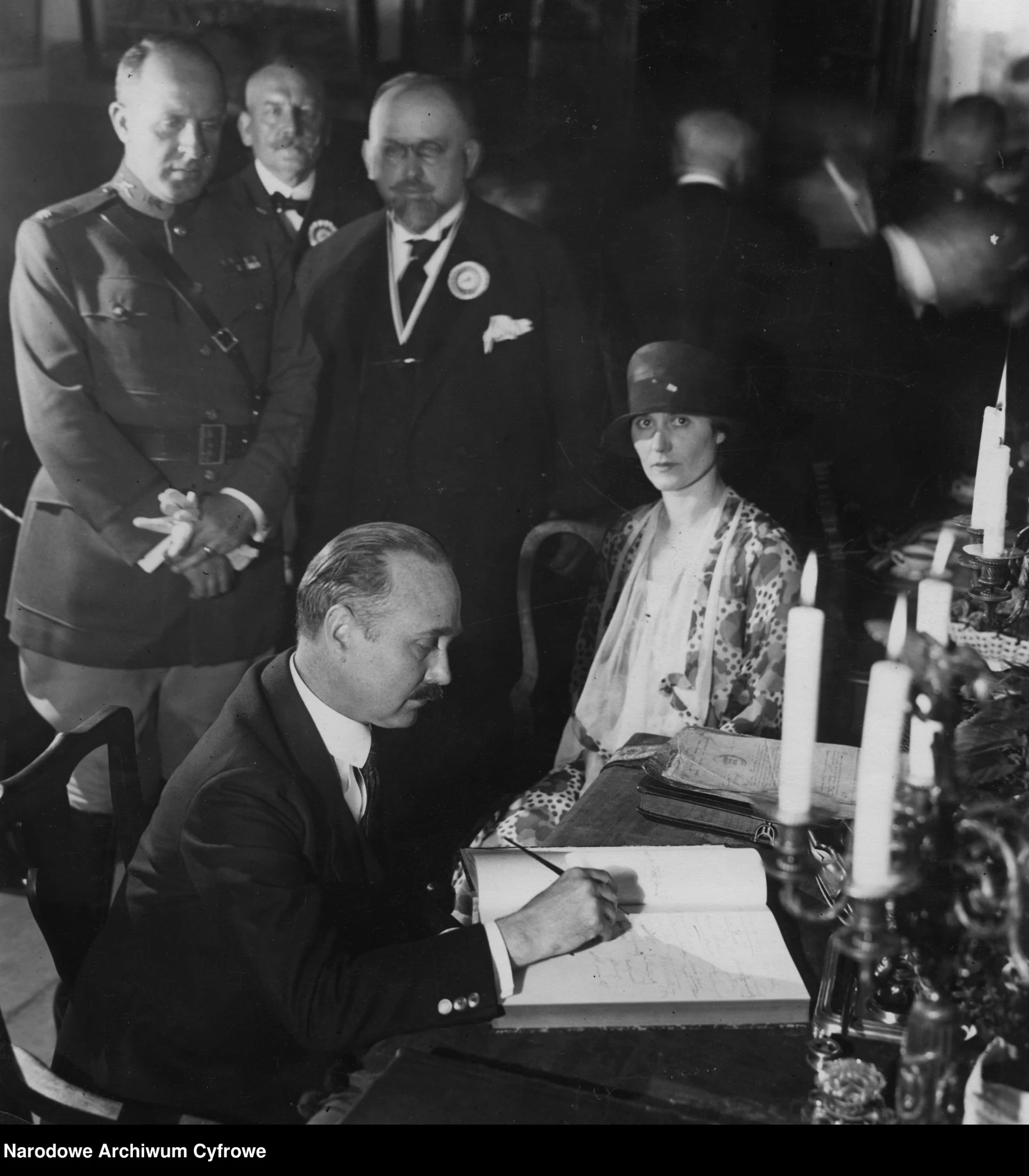 John Stetson signing the Fukier guest book in 1926, his wife seated beside him