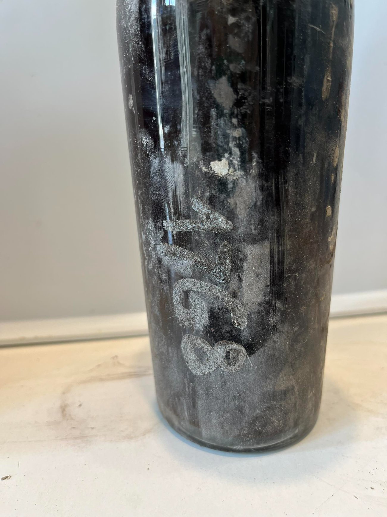 Numerals written in white on the dark glass of the same bottle