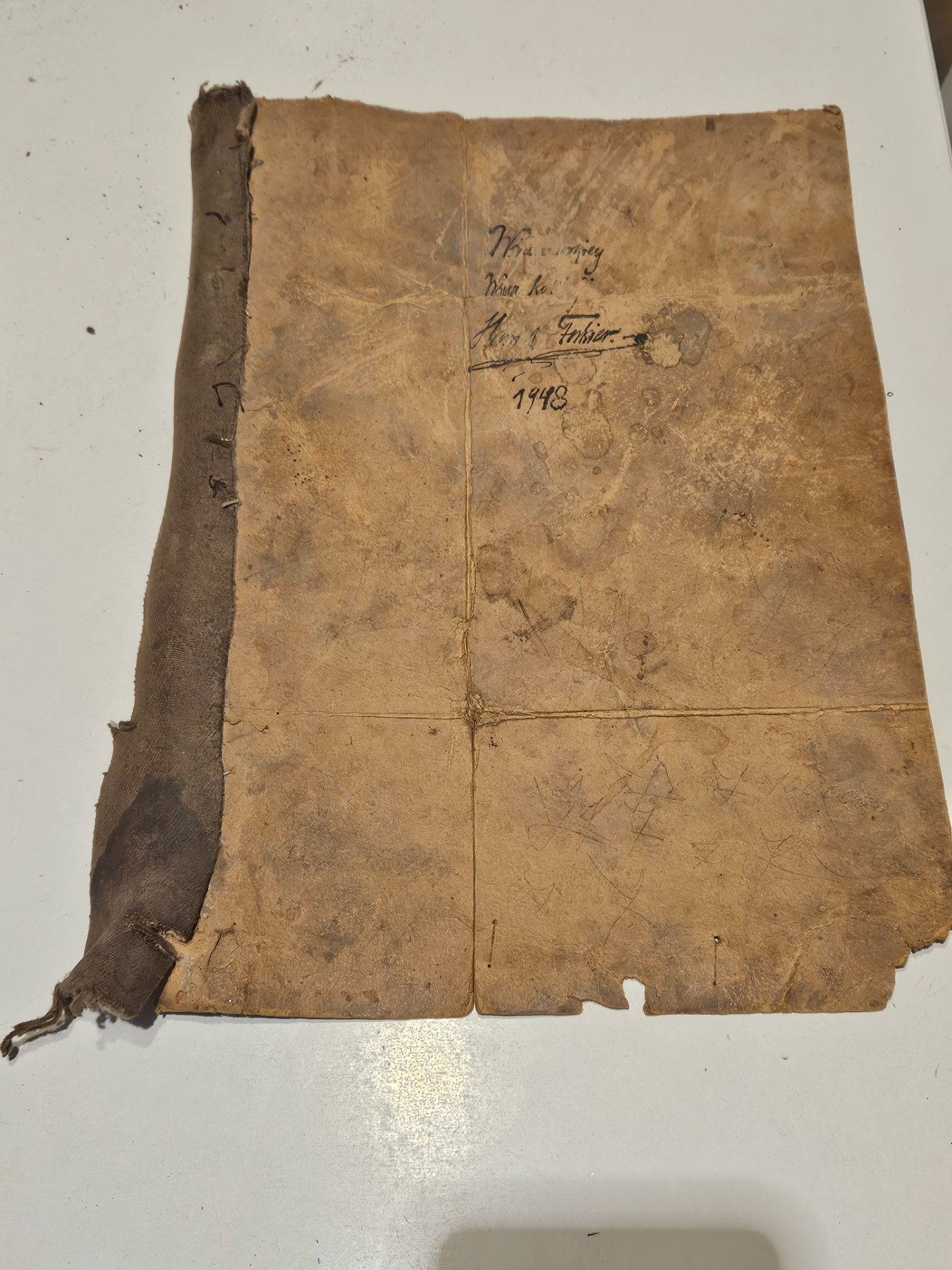 The other face of the wrapper, inscribed in ink and signed Henryk Fukier, 1948