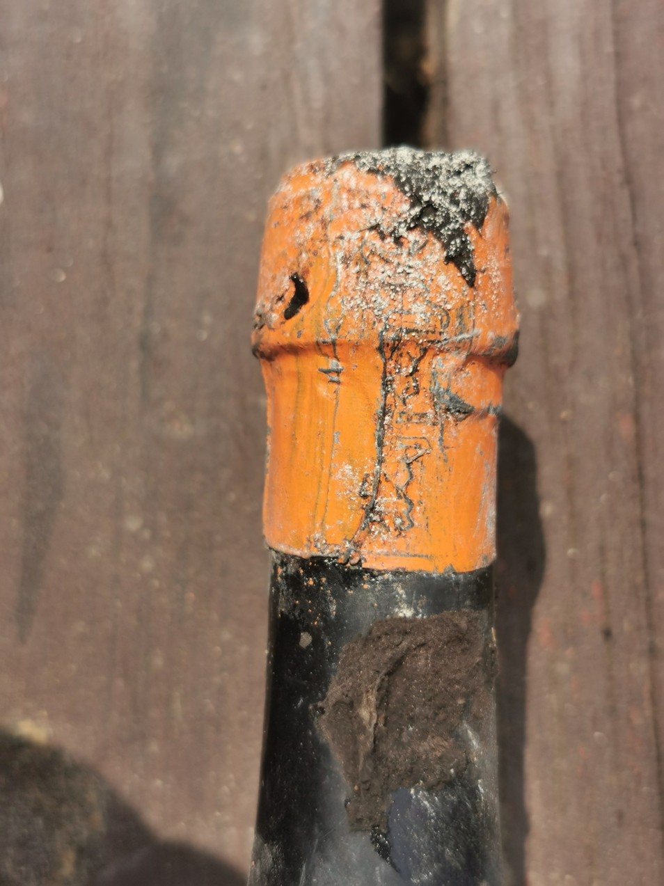Orange lacquer capsule on the 1811 Hofkeller bottle, the embossing partly crusted over