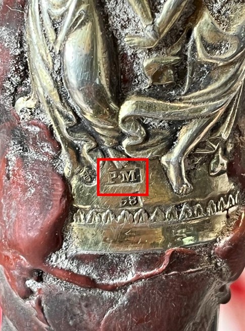 The silver mark PM on the capsule band